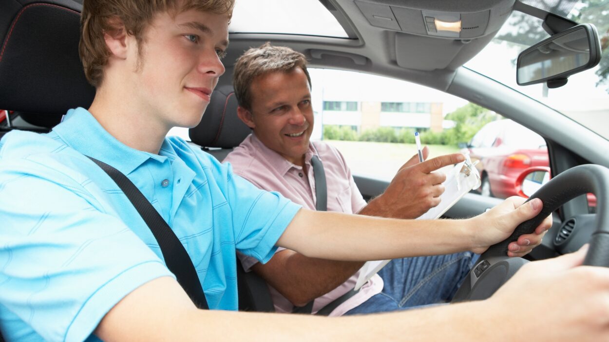 teenage boy taking driving lesson 759568169