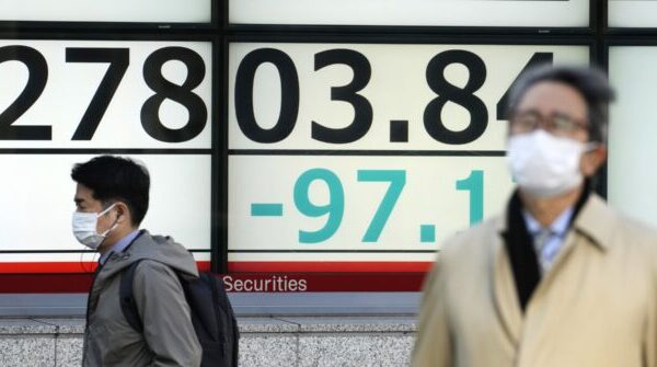 japan financial markets people walk an electronic stock board japan nikkei 225 front of securi 640x335